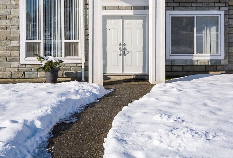Clear walkway leading to a front door between two banks of snow